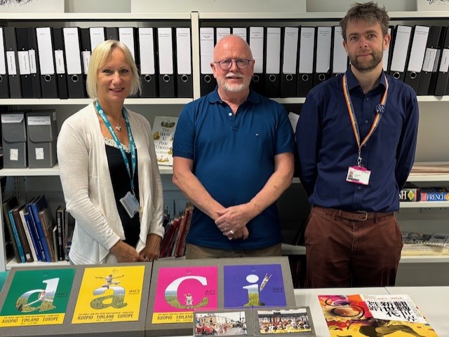A representative of daCi and two members of the Archive Team stand behind a display of archive material from the daCi Archive.