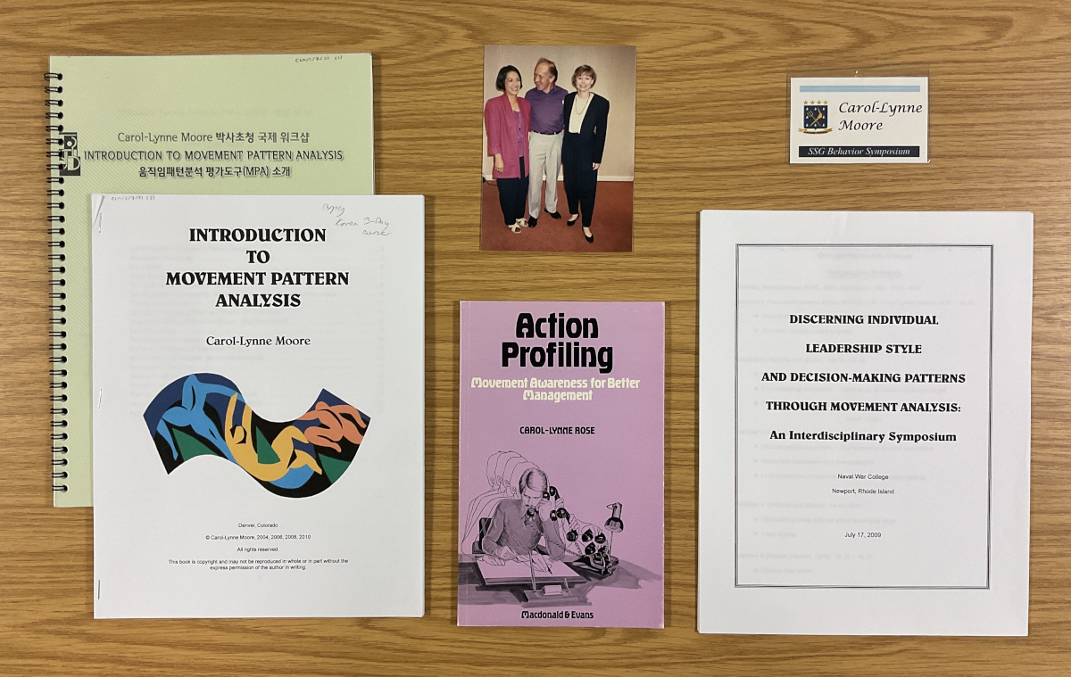 Documents from the collection, including a published book, a Korean-language instruction, an ID badge, and a photograph featuring three people.