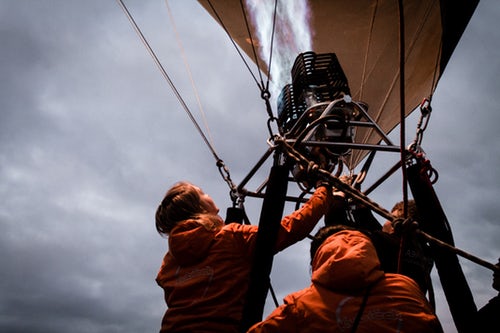 3 people working on the starting system of a hot air balloon