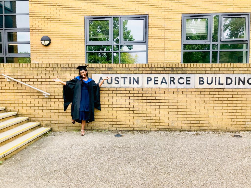 Toni outside the Austin Pearce building in graduation robes