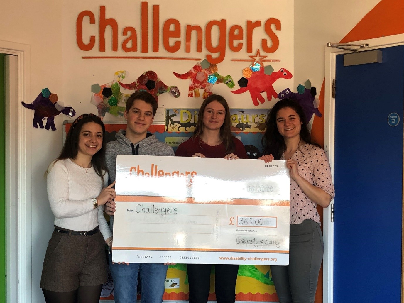 4 University of Surrey students holding a cheque for £360 for Challengers