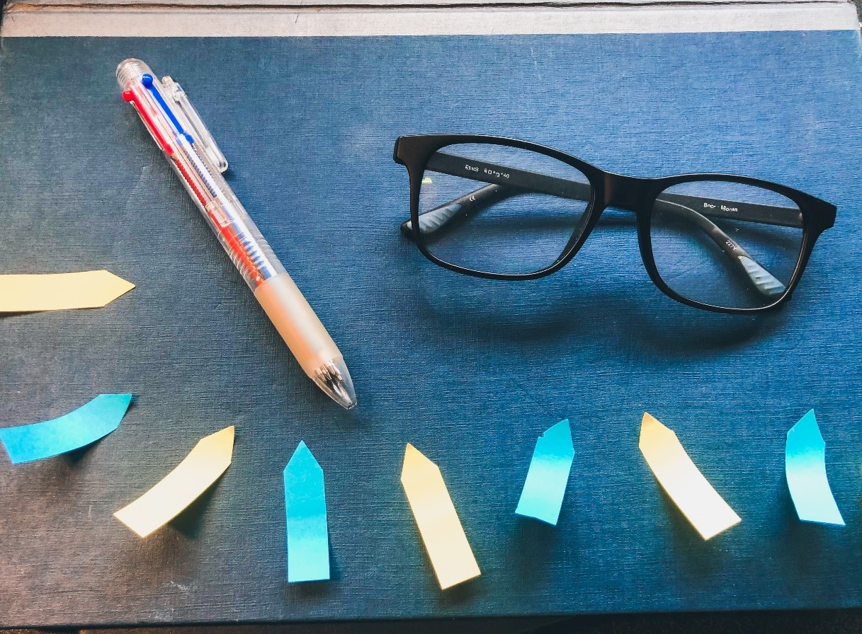 Some post it notes, a pen and a pair of glasses