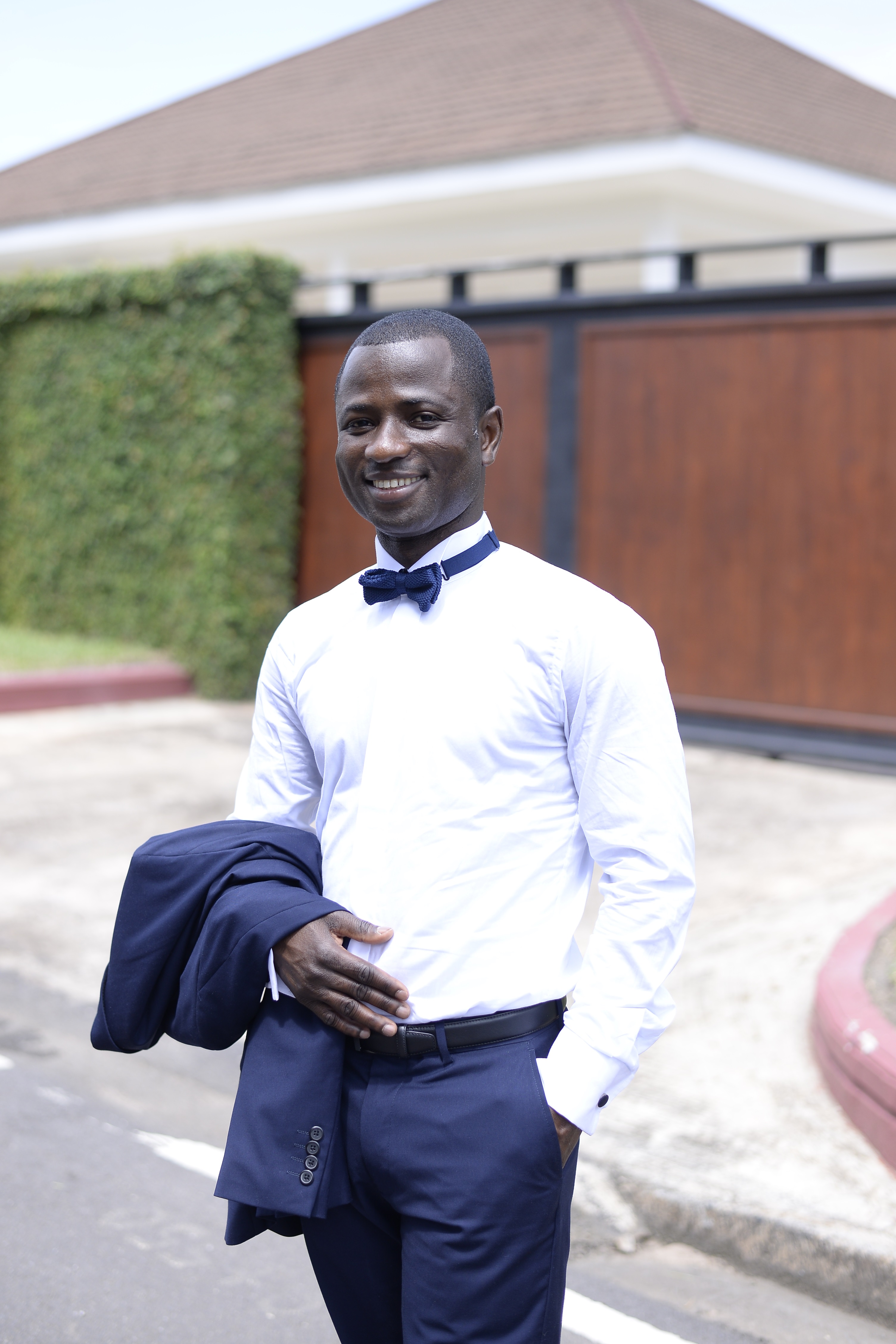 George Nipah wearing a smart suit and bow tie, smiling