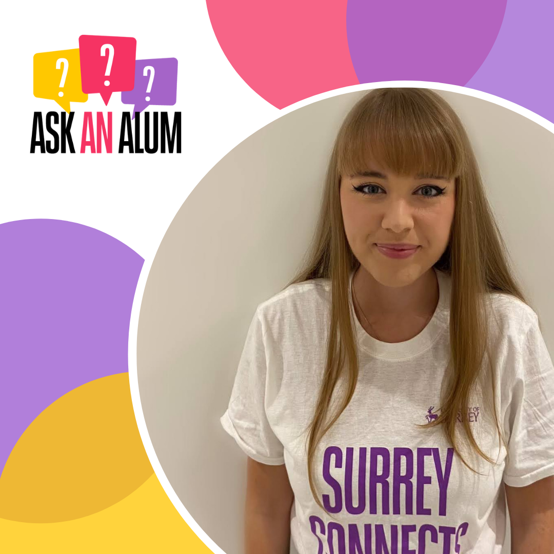 Laura is smiling and wearing a Surrey Connects T-shirt in a design with 'Ask an Alum'