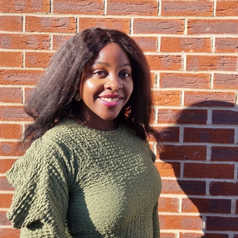 Jamina standing in front of a brick wall