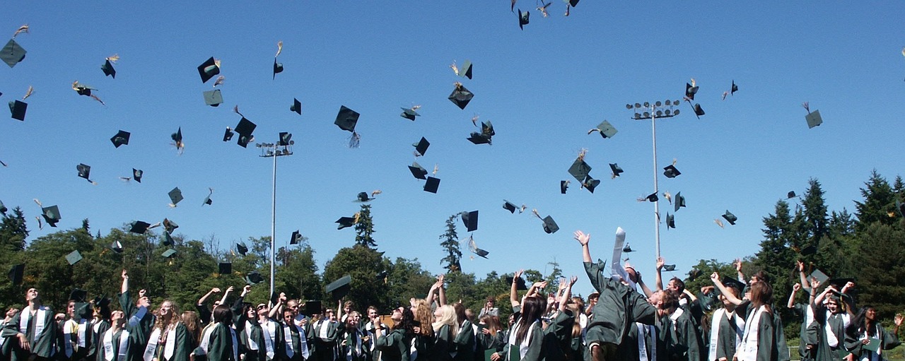 Graduation image, with graduation caps being thrown in the air