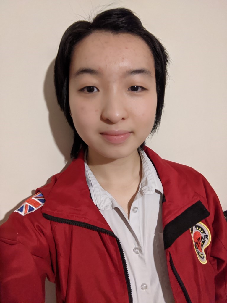 Photo of Katey in her City Year uniform and lockdown haircut against a cream background.