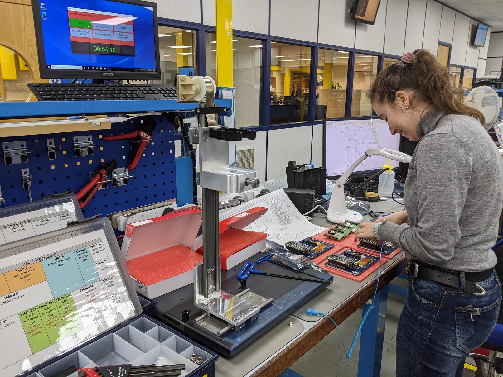 Lisa working on a circuit board during her engineering placement at Stanhope-Seta. She is surrounded by equipment and computers