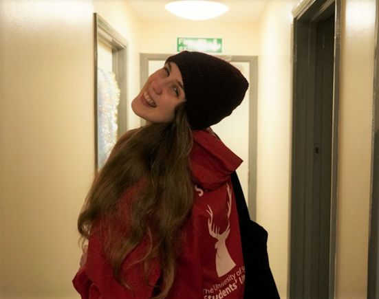 A young woman with long blonde hair wearing a red hat and a red rain coat