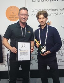 Louis holding a bottle and a man holding a certificate