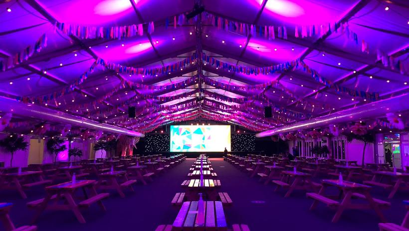 University of Surrey Students Union venue, The Marquee. Big tent with purple LED lights, fairy lights and picnic tables all COVID safe and well spaced apart