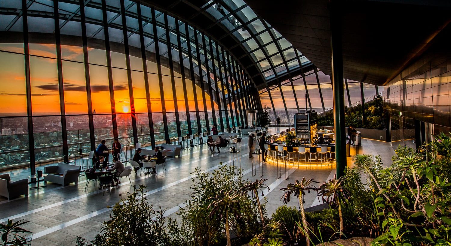 View of the Sky Garden overlooking London at sunset. Plants and greenery for decoration and small bar with seating area