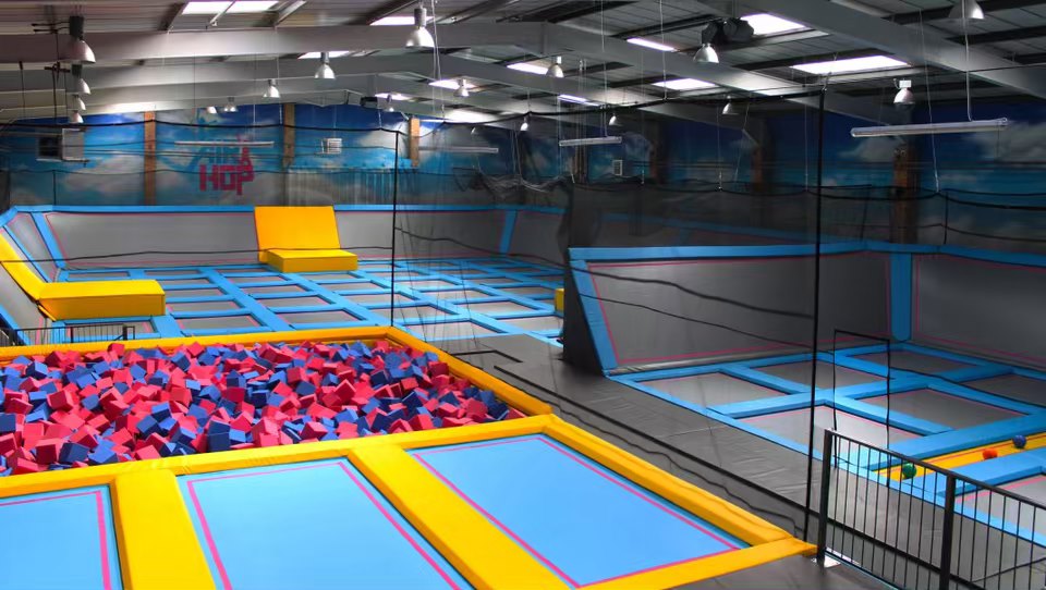 A photograph of Airhop Guildford empty. It shows a series of trampolines and a pit filled with foam cubes