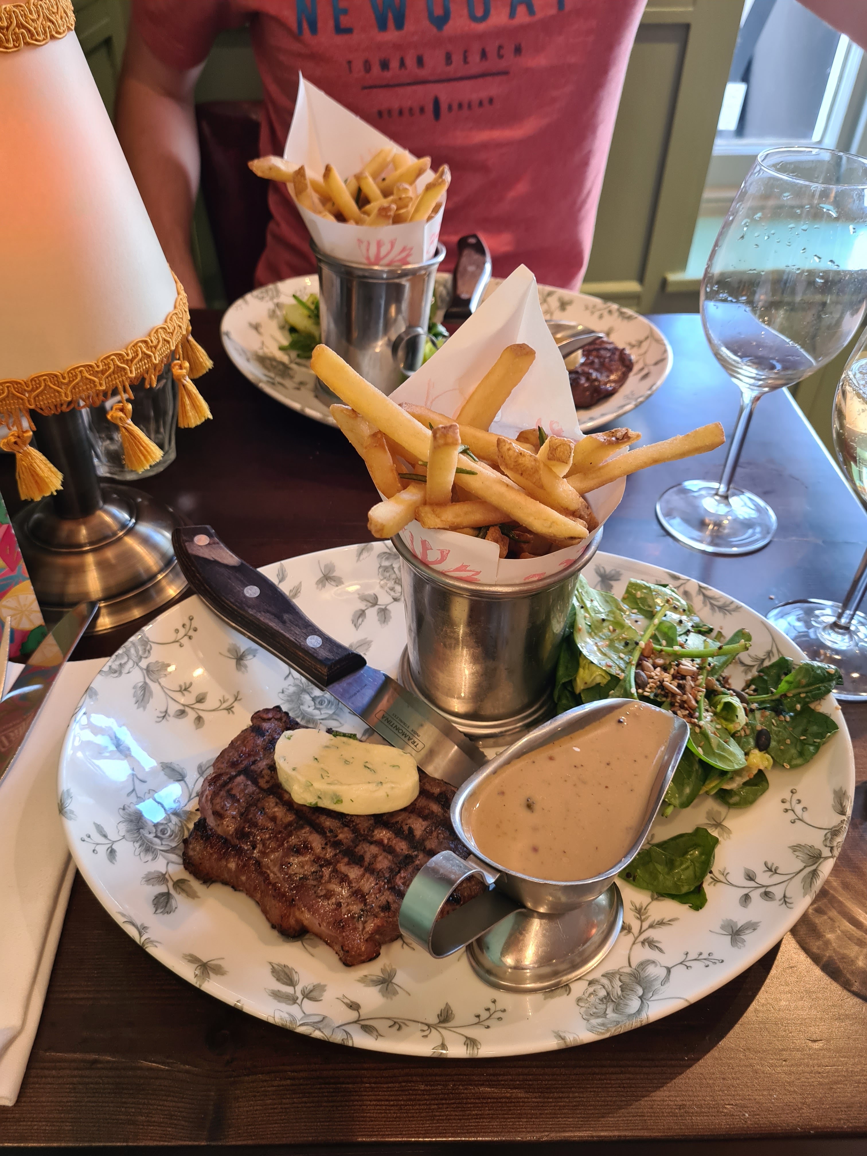 A photograph of two steaks with chips and a salad. Taken at Bill's in Guildford