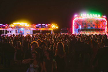 Gradball 2017 event for graduating students put on by the University of Surrey Students Union. Students in field with fair ground rides pictured