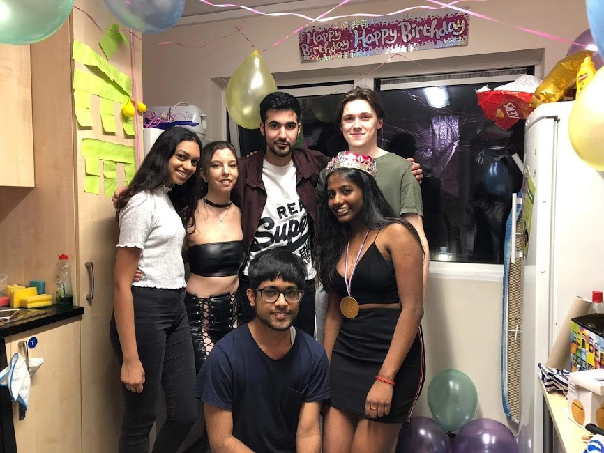 Students in University of Surrey accomodation kitchen at a birthday party.