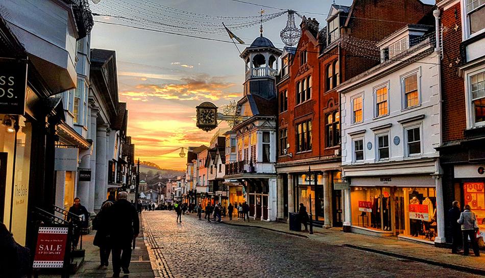 Guildford high street with sunset and clock in view