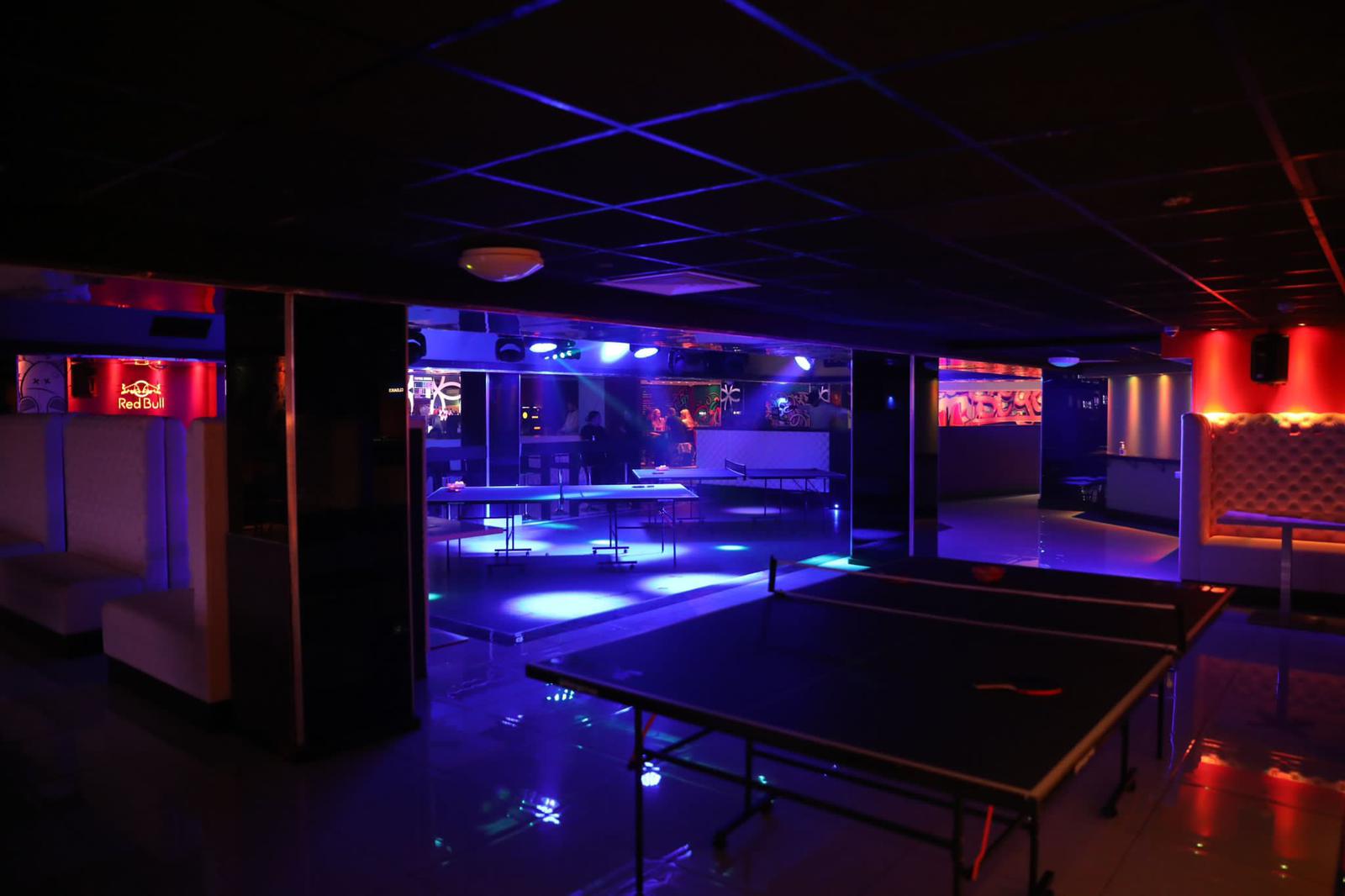 Table tennis tables in bar with strobe lighting and DJ booth at Slice Guildford 