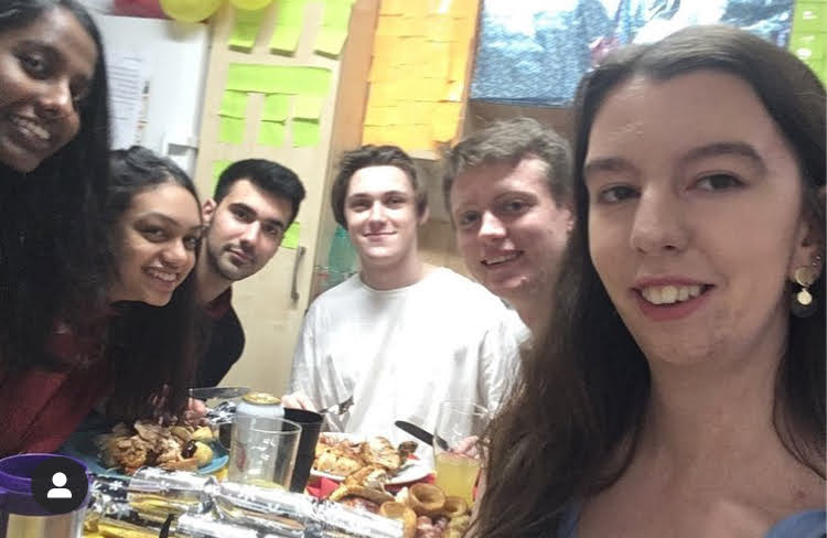 Friends sit around a table sharing a meal