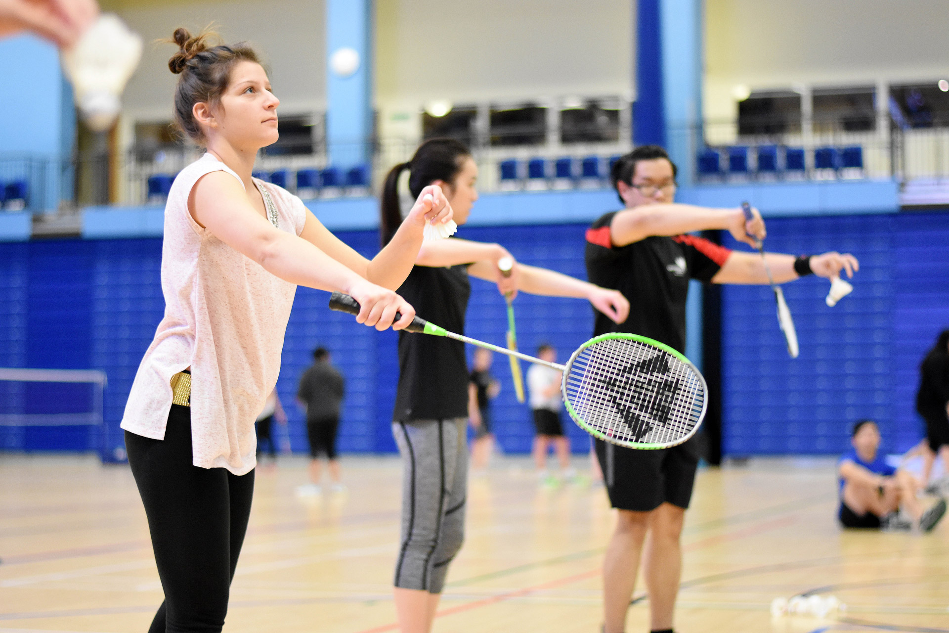 3 students practice Social Badminton. 