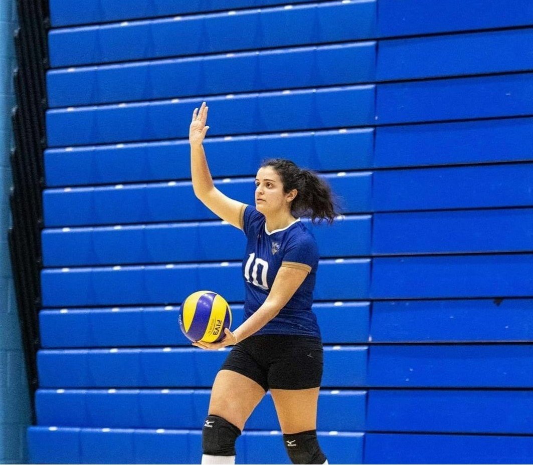Alessia serving the ball during a match with the Surrey Volleyball Club.