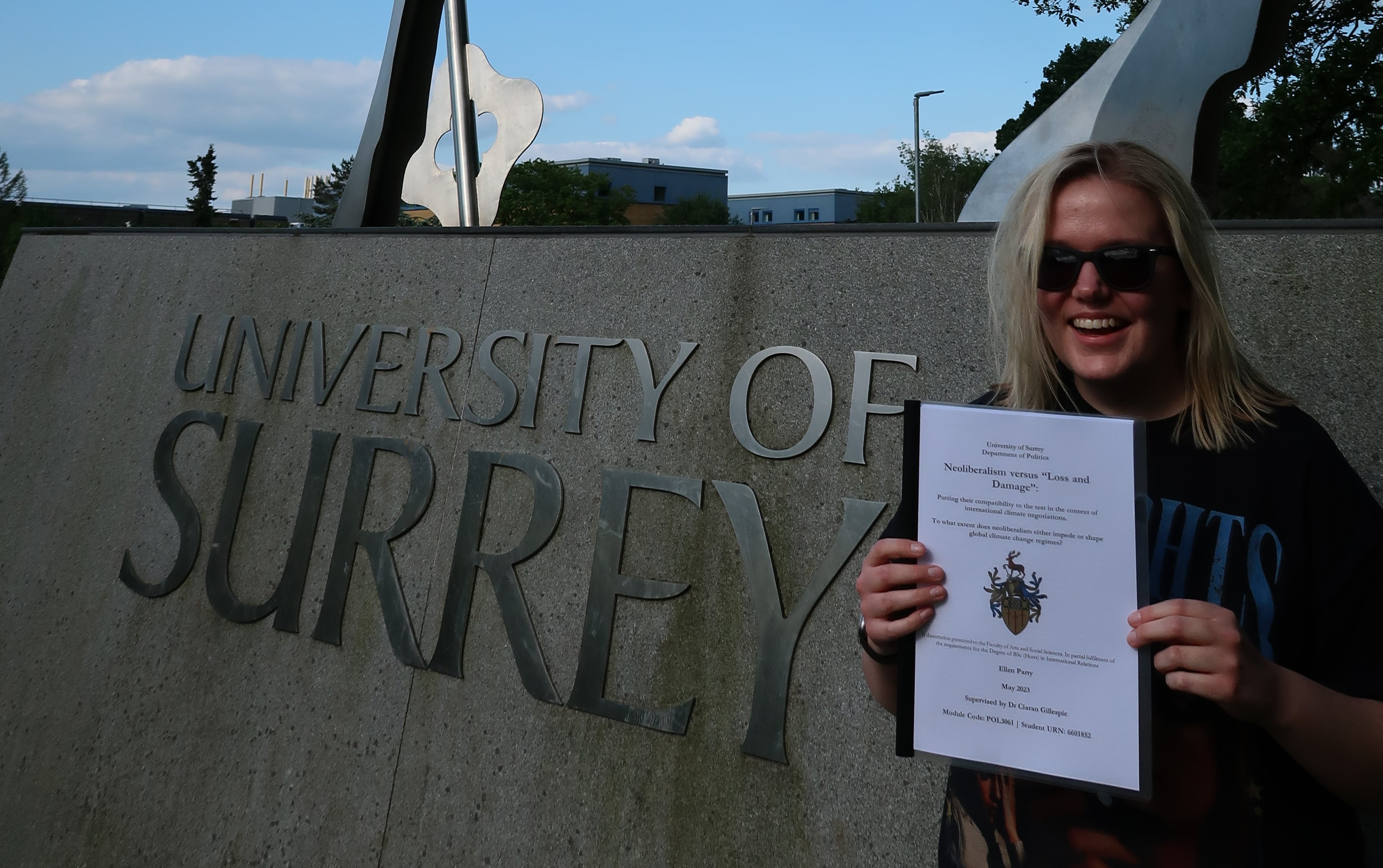 Me standing infront of the Stag statue holding my dissertation. 